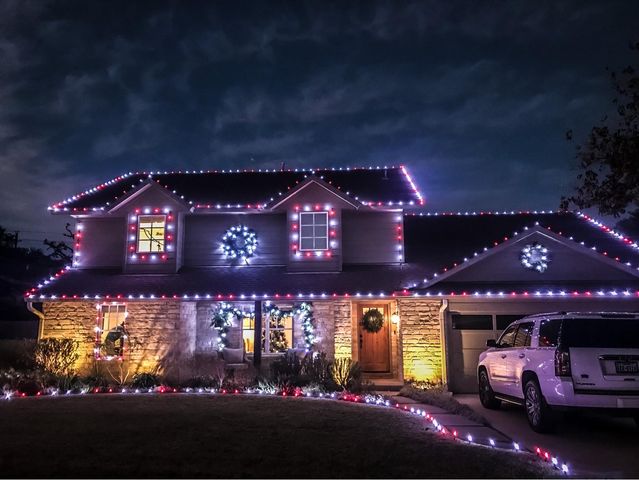 large house with installed colorful lights and car
